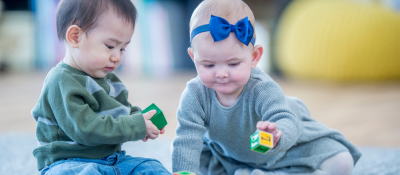 Two babies playing with blocks