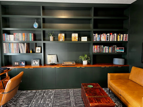 Dark green office built-in shelving and cabinetry styles with books, records, and record player