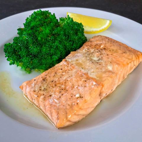 baked salmon with lemon and broccoli on a white plate