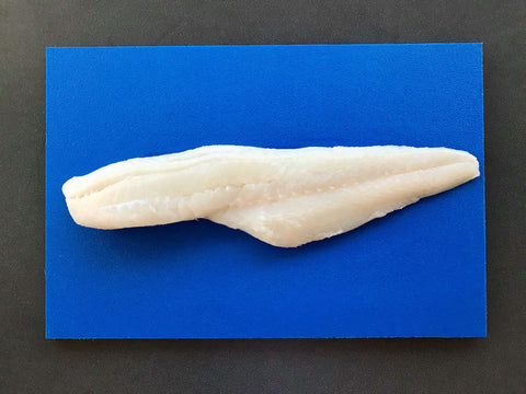 fresh cod fillet on a blue cutting board on top of a table