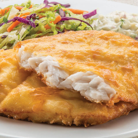 cooked fish with white meat showing served on a white plate with coleslaw