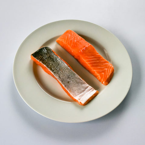 two organic salmon portions on a white plate