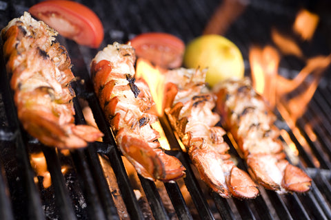 Lobster tails being cooked on a grill