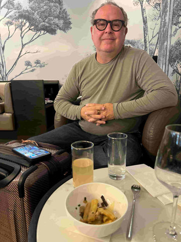 John sitting in a comfy chair in the airport lounge
