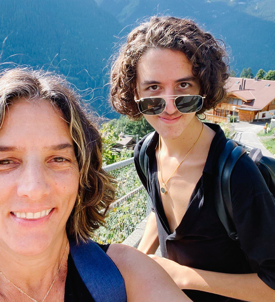 Elli Milan and her son Dino standing at the top of the Swiss Alps smiling