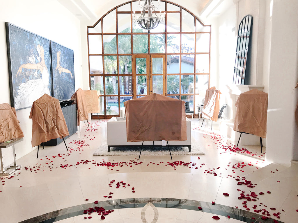 Romantic artwork display with red rose petals scattered across the floor for the Milan Art - Art Show