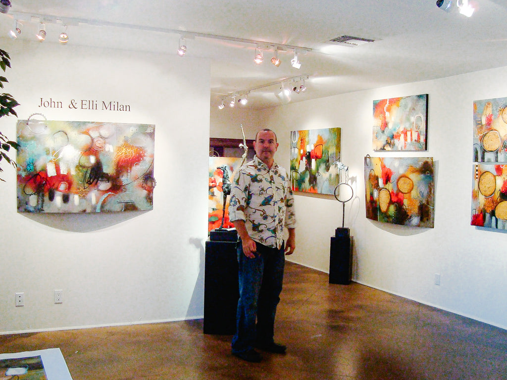 Elli and John Milan's solo exhibition "Heavens Exchange" - artist john milan posing in art gallery of abstract art by artist couple. Two hearts one canvas