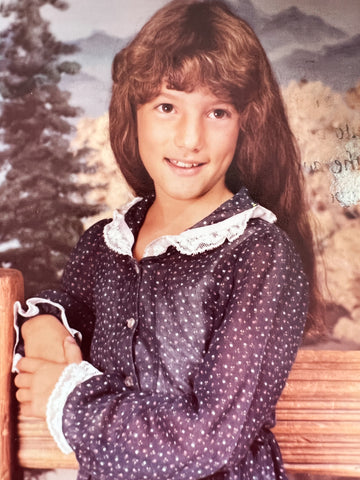 3rd Grade Elli Milan smiling with long flowly hair and a polka dot dress