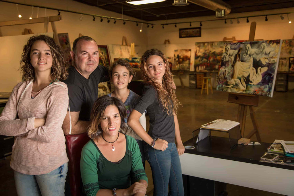 An older photo of John and Elli Milan posing in their studio in Arizona with their three daughters
