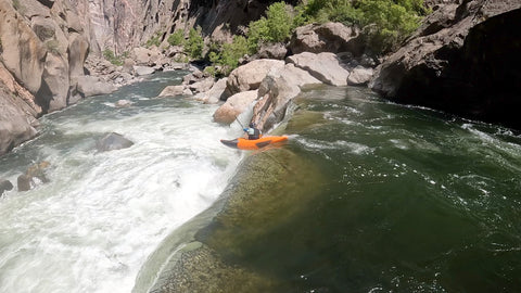 orange kayaking going over falls