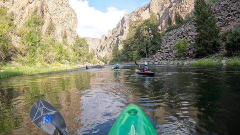 Green Kayak entering black canyon