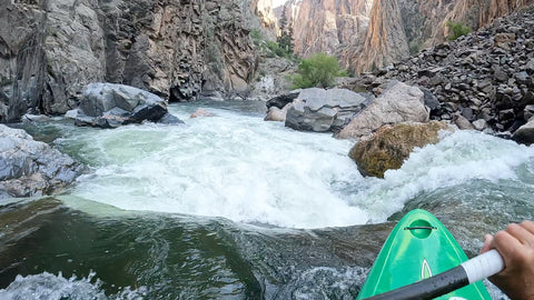 Green kayak dropping into upper intestine rapid