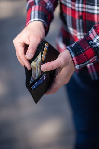 Man opens wallet to show cards and cash inside