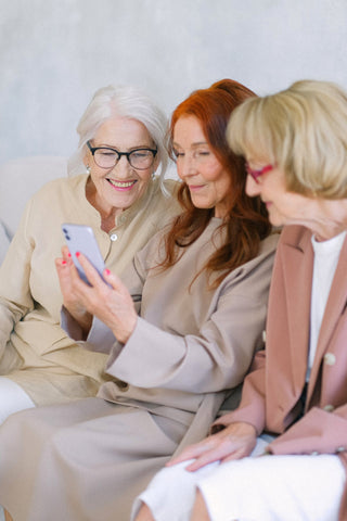 Group of older ladies smiling at a phone