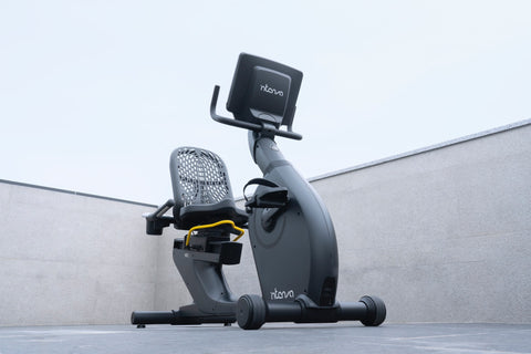 Recumbent exercise bike against a two-tone grey background
