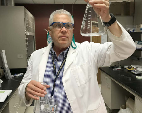 Dr. Andy Clark holding two empty Erlenmeyer flasks in a scientifically heroic pose