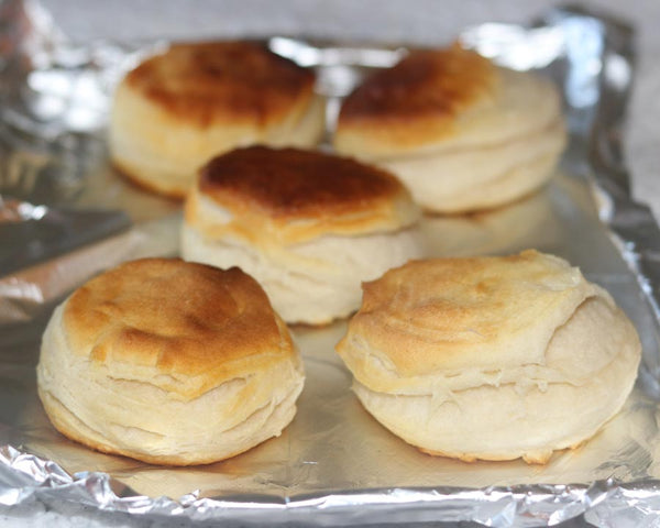 Five yeast rolls sitting on aluminum foil