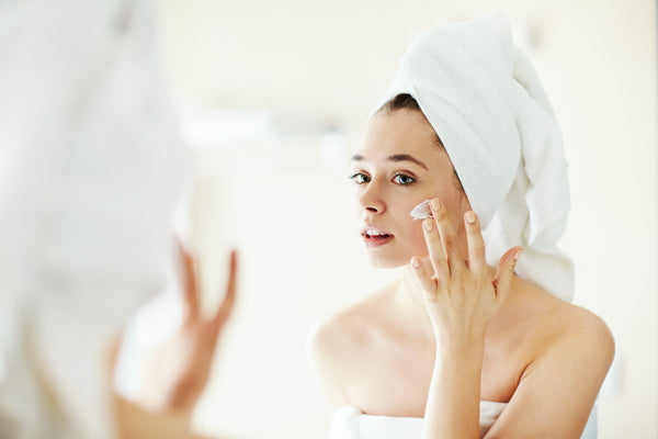 Woman applying moisturizer