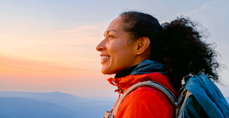 African American woman in her 50's hiking at sunset
