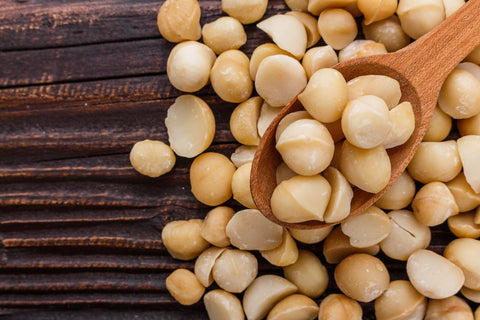 Pile of macadamia nuts without a shell on a wooden board