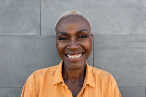 African American woman wearing orange shirt outside smiling
