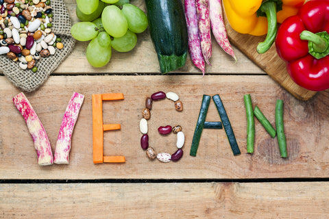 Word vegan spelled out with vegetables and beans