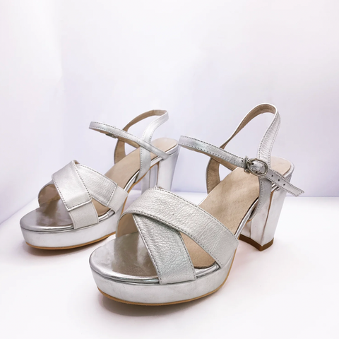 The image displays a set of silver heels with strappy sandal-like design.