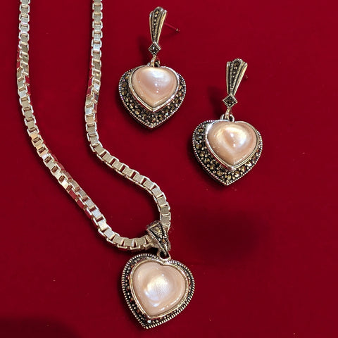 Pink mother of pearl hearts with sterling silver and marcasite setting. Pendant and matching earrings.