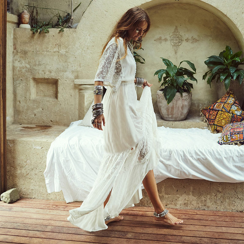 Mujer joven caminando con vestido ibicenco blanco