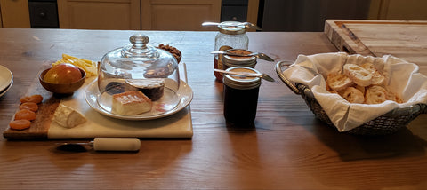 spread of cheese, jams, bread on cutting boards