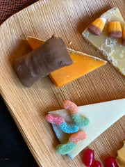 three slices of cheese with different types of halloween candy including gummy worms, candy corn and butterfinger