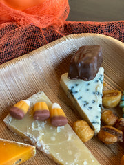 Blue cheese with a fun size twix and cheddar with caramel candy corn on a fallen leaf plate