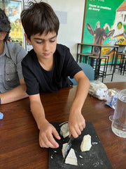 Boy eating a piece of a cheese from a cheese plate