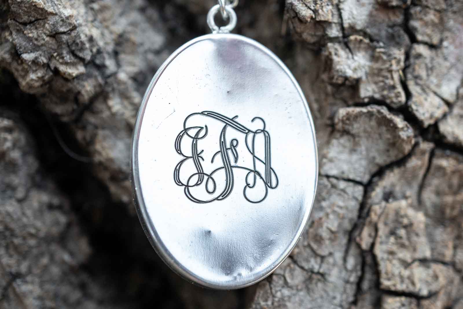 A monogram engraved on a pendant on a chain