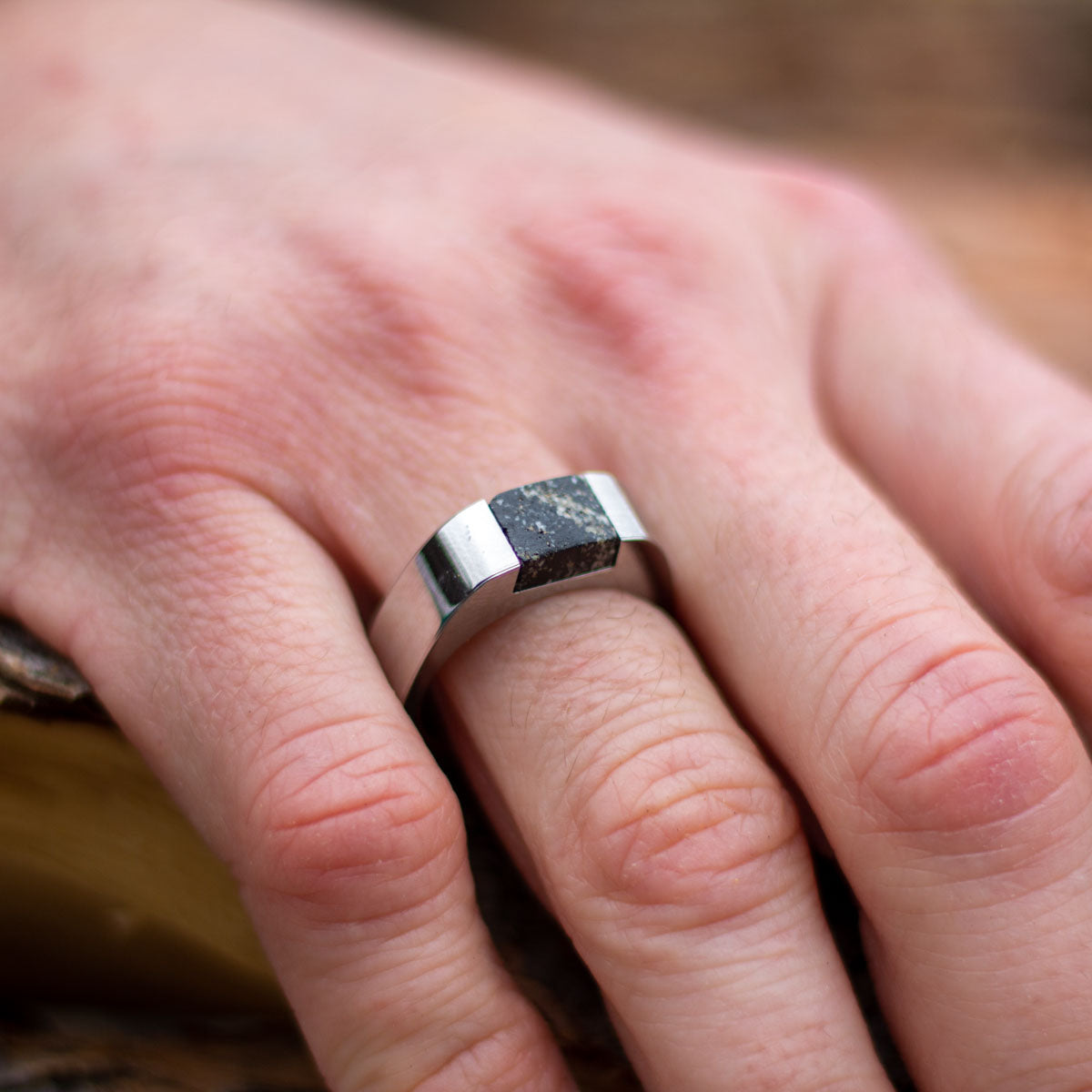 Man wearing stainless steel ring with inset natural granite stone