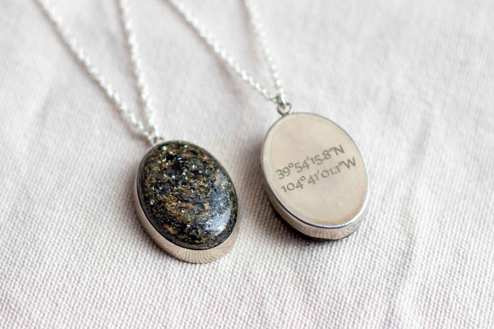 Stone pendant necklace with latitude and longitude coordinates engraved on the back