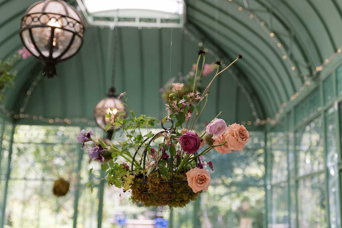 Hanging maroon, lilac, and mauve flower basket at a botanic gardens wedding