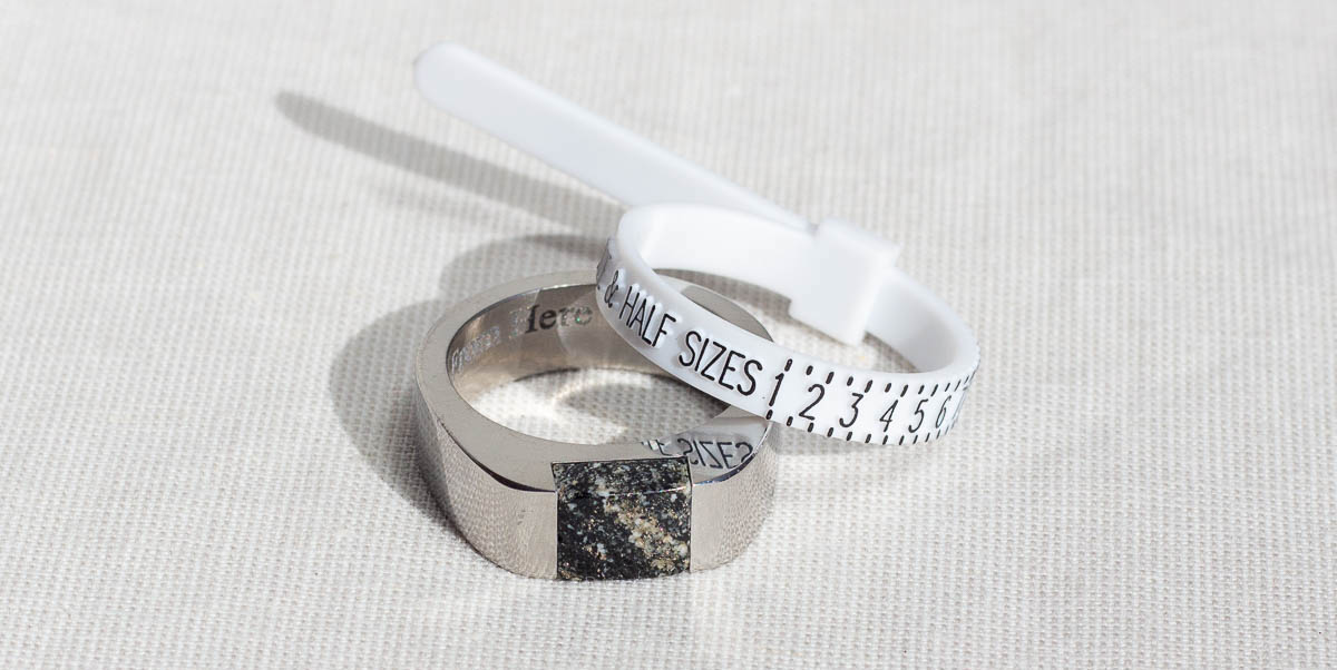 Wedding ring gauge next to the Signpost Signet ring inset with a piece of granite