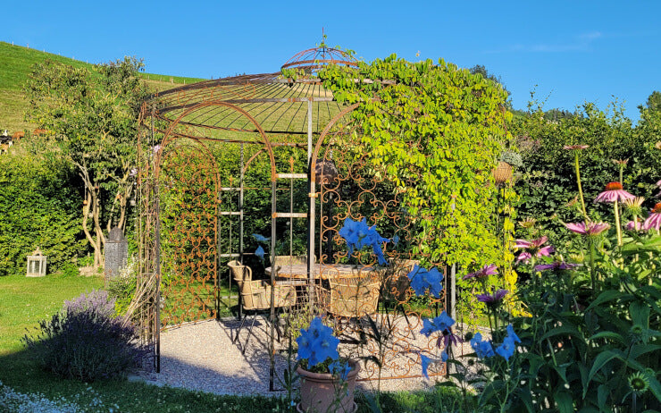 ELEO Pavillon Florenz in Edelrost im Garten an einem Hang