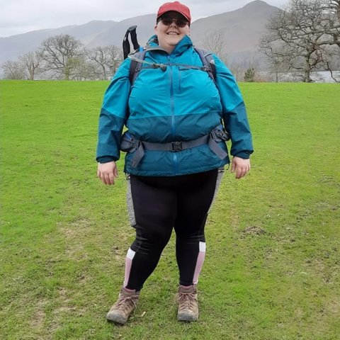 fat woman wearing green waterproof coat, looking happy