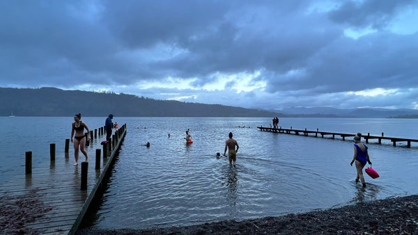 People swimming in a lake at dawn