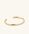 Slim Cuff: A gold bracelet with a minimalist design and an engraved letter M. Ideal for versatile fashion pairings.