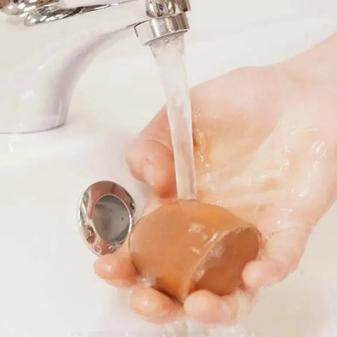 makeup sponge being washed by hand