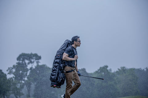 man playing golf in rain