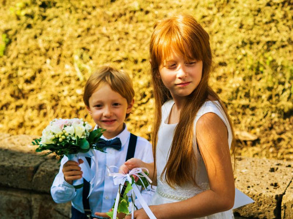 A ring bearer and a flower girl at a summer wedding