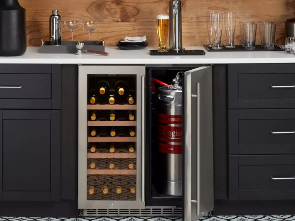 Front view of a modern kitchen with a 6.3 Cu Ft Wine Outdoor Refrigerator With Single Tap Kegerator installed under the kitchen counter. One door is open, revealing a compartment containing a stainless steel keg