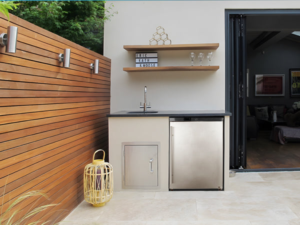 Front view of the 5.4 Cu Ft Stainless Steel Undercounter Outdoor Refrigerator installed in an outdoor kitchen setting. The refrigerator is positioned under the kitchen counter