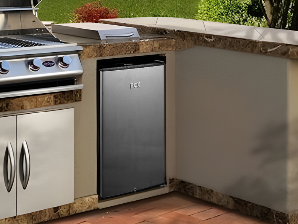 Side view of an outdoor grill station featuring the 4.1 Cu Ft Stainless Steel Outdoor Beverage Fridge 156 cans installed under the kitchen counter.