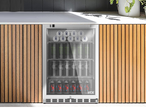 Front view of the outdoor setup with the 5.12 Cu Ft Beverage Outdoor Refrigerator 132 cans installed in a suitable place. A flower pot is positioned above the fridge
