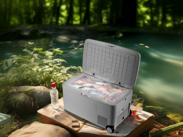 Side view of a camping site with the 0.6 Cu Ft Camping Outdoor Refrigerator positioned near the river. The product's door is open, revealing the interior space filled with fishes